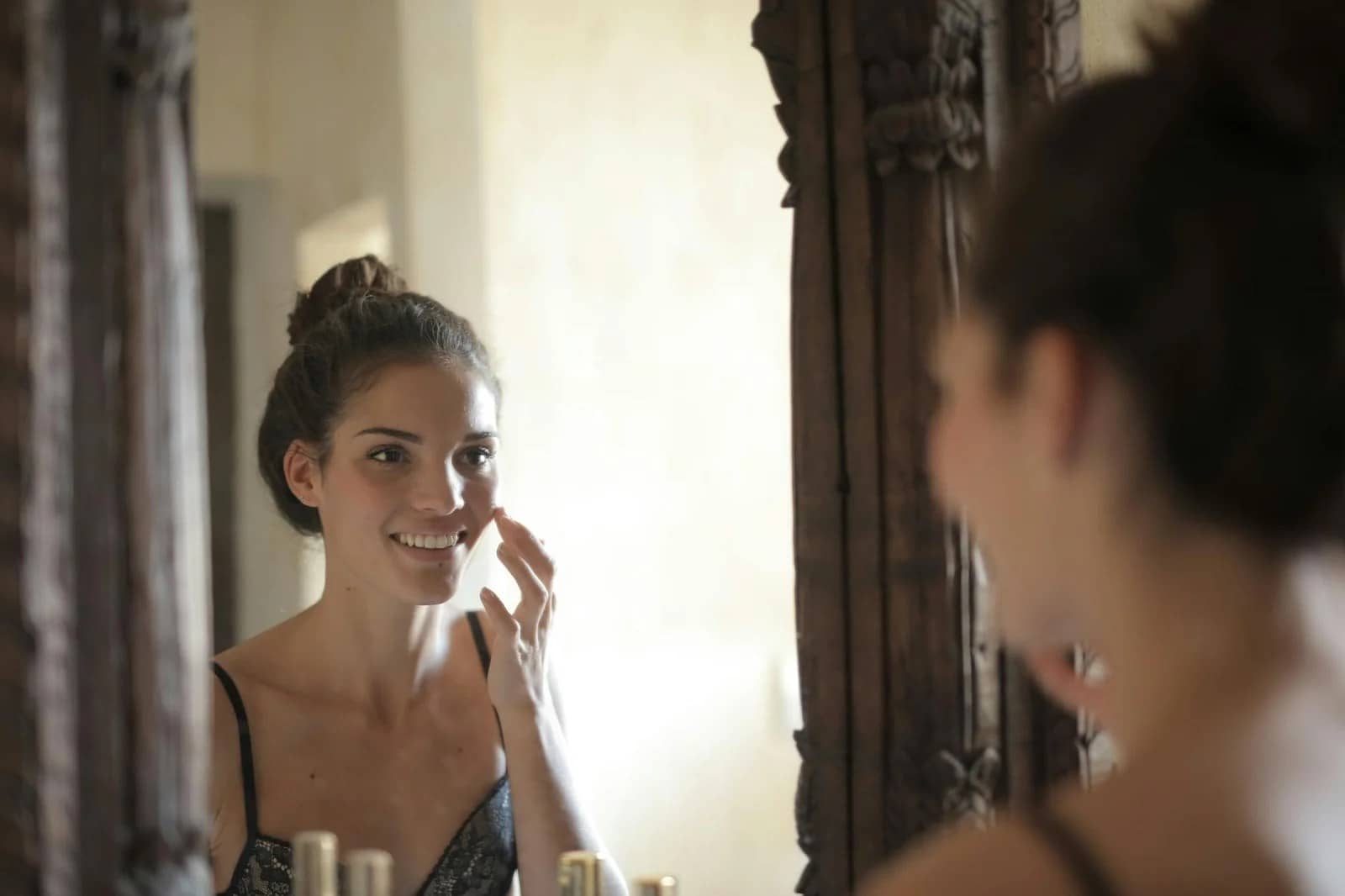 woman touching her cheek: Best Anti-Wrinkle Cream