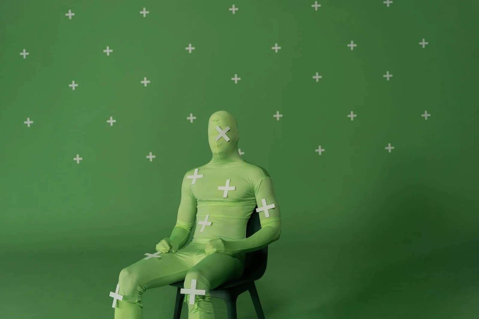 a person in zentai costume sitting on a black chair