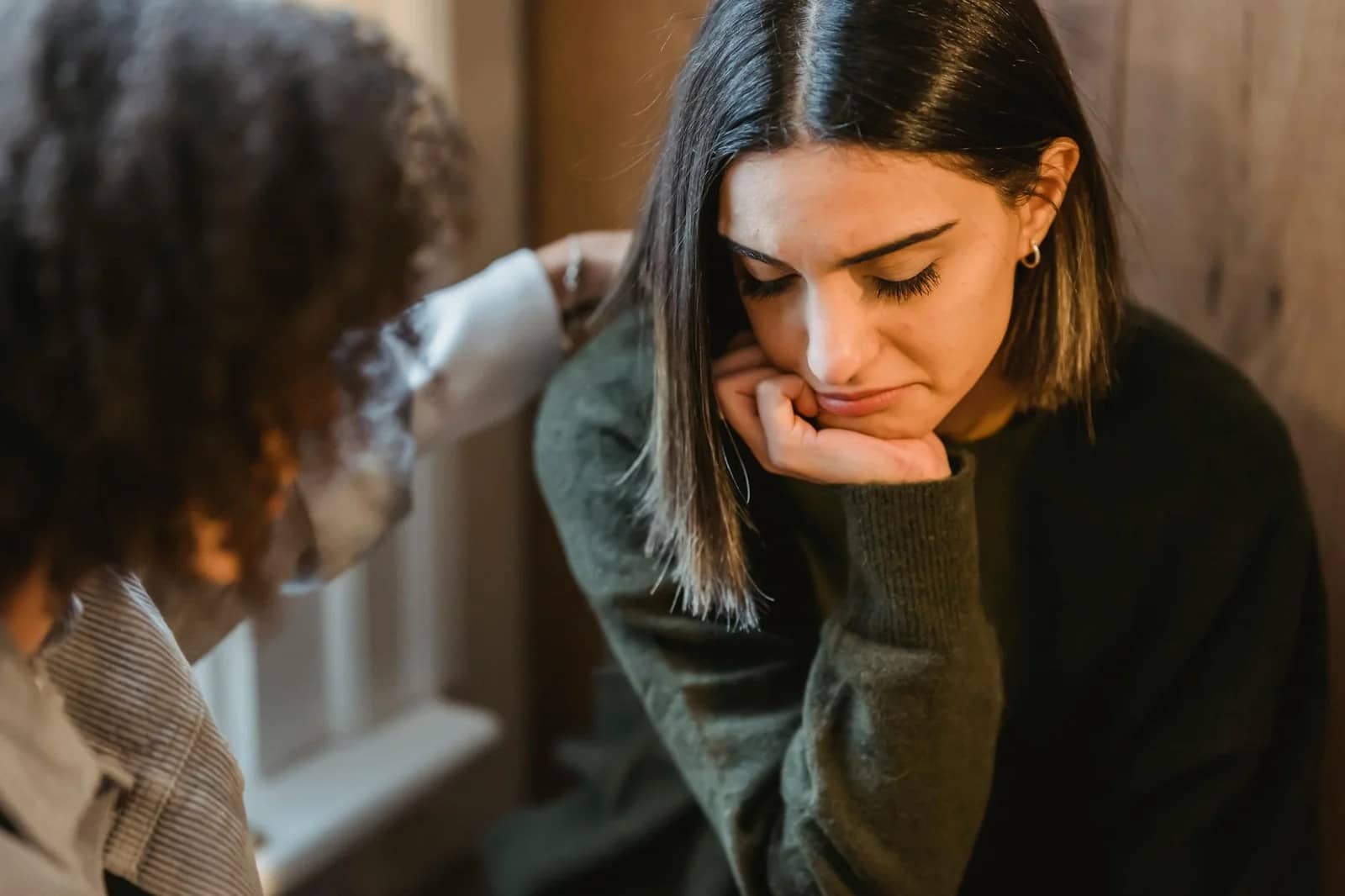 crop woman tapping shoulder of frustrated female friend