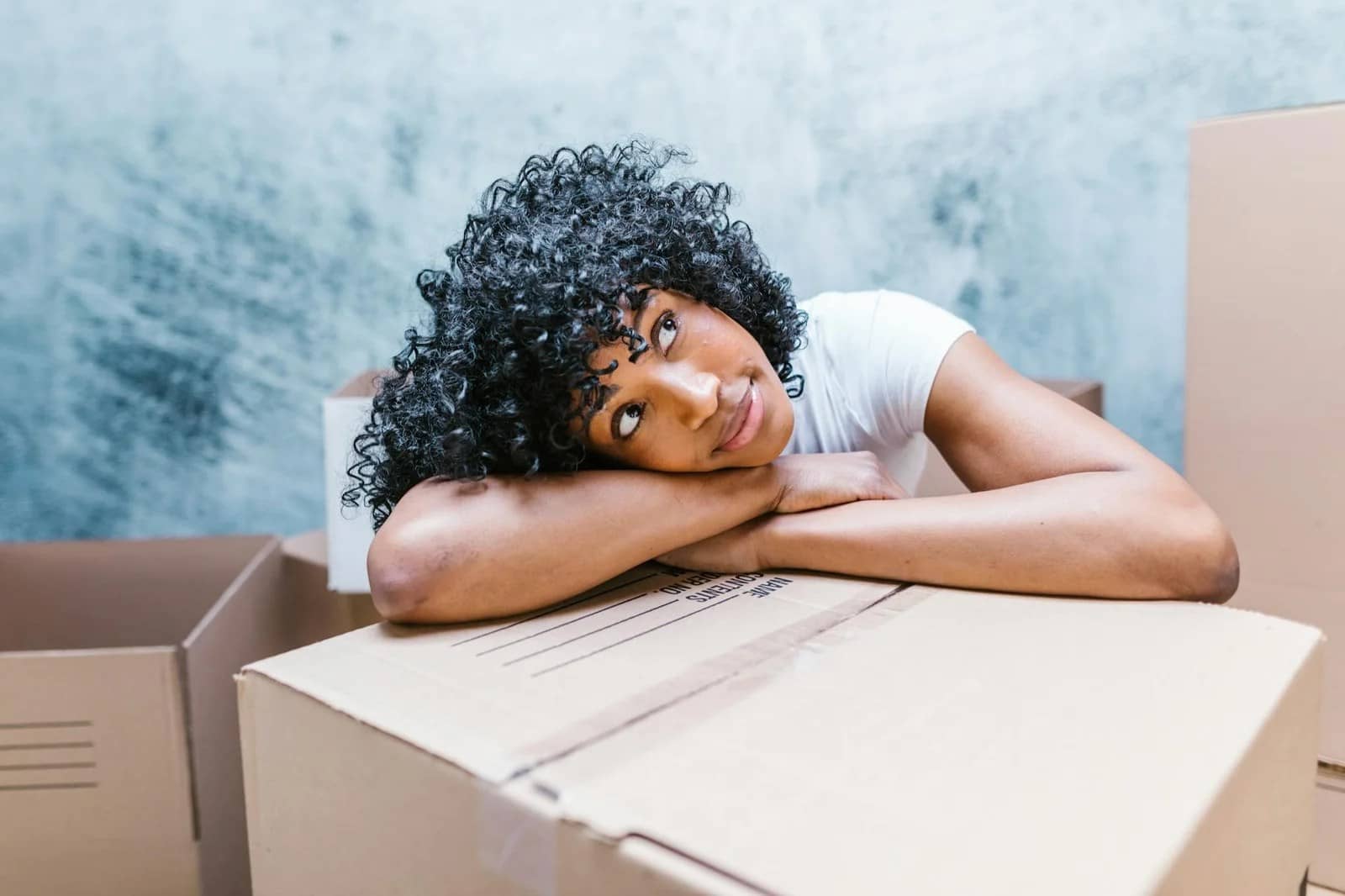 a woman resting her head on a cardboard box - Menopause symptoms